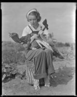 Inez Courtney, actress, holding a hatchet and a turkey, circa 1934-1939