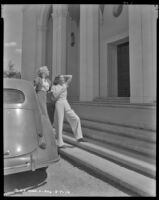 Woman and Louise Stanley, actress, exiting a car and looking up at a building, circa 1938