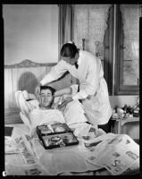 Fred Keating, actor, at home in bed as his valet attends him, Los Angeles, 1934