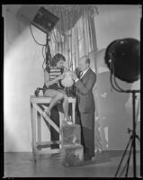 Barbara Read, actress, looking at a globe with a man, circa 1934-1936