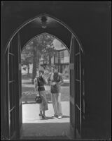 Johnny Mack Brown, actor, and a woman seen through an arched doorway, Lake Arrowhead, circa 1929-1934