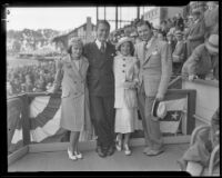 Four people, with Lyle Talbot, actor, at the far right, posing together in the stands at an event, circa 1932-1939