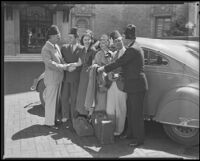 Group of people, with Lyle Talbot, actor, second from the left, wearing Shriners fezzes and shaking hands, circa 1932-1939