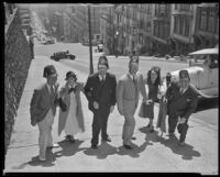 Group of people, with Lyle Talbot, actor, at the far right, wearing Shriners fezzes and walking up a steep street, probably San Francisco, circa 1932-1939