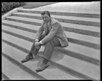 Lyle Talbot, actor, sitting on steps that may be on the grounds of the Hotel Del Monte, circa 1932-1939
