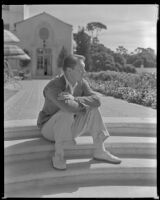 Man sitting on the steps by the sun terrace of the Hotel Del Monte, Monterey, circa 1932-1939