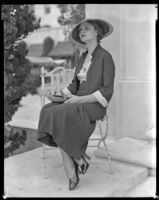 Woman sitting on a chair in front of what may be the Hotel Del Monte, circa 1932-1939