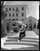Woman sitting on the steps by the sun terrace of the Hotel Del Monte, Monterey, circa 1932-1939