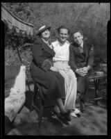 Joseph Schildkraut, actor, sitting on a table between a woman and a man, circa 1934