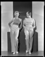 Two women leaning on a platform with their hands in their pockets, circa 1926-1939