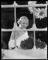 Virginia Pine, actress, sitting behind a snow covered window, circa 1934-1935