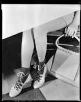 Fay Wray's legs and hand holding a handbag, circa 1931-1938