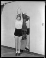 Billie Seward, actress, standing on her toes and stretching her arms above her head, circa 1934-1935