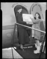 Edith Fellows, actress, pointing to the words "handle with care" on a package she is handing to an American Airlines stewardess, circa 1935-1939