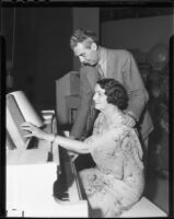 Arthur Johnston, composer, stands beside a blind pianist seated at a piano, circa 1936