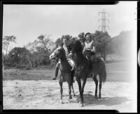 Marian Marsh, actress, riding horses with a man, circa 1935-1939