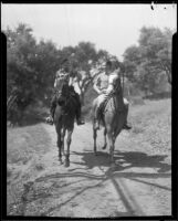 Marian Marsh, actress, riding horses with a man, circa 1935-1939