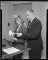 Marian Marsh, actress, showing fingerprints to a man, Los Angeles, circa 1935-1939