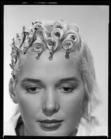 Beverly Michaels, actress, with half of her hair pinned up, circa 1951