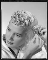 Beverly Michaels, actress, pinning up her hair, circa 1951
