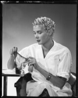 Beverly Michaels, actress, holding a hair net, circa 1951