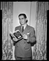 Theodore Pratt, author, holding a copy of his novel, Mr. Winkle Goes to War, circa 1944