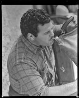 Claude Binyon, screenwriter, drinking from a canvas water bag on the set of Arizona, circa 1940