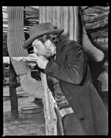 Porter Hall drinking from a basketry dish on the set of Arizona, circa 1940