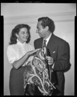 Charlita, actress, and a man holding an embroidered cape, circa 1951