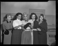 Charlita, actress, and four women admiring a matador's hat, circa 1951