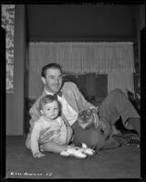 Lee Bowman, actor, at home with son Lucien and cat, circa 1943-1944