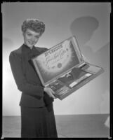 Woman holding a box labeled, "McGregor good luck gifts for the Armed Forces", 1940s