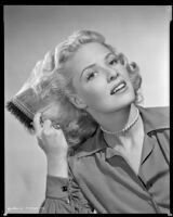 Janis Carter, actress, combing her hair, 1946