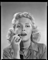 Janis Carter, actress, applying lipstick, 1946