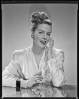 Janis Carter, actress, applying a beauty product to her face, 1946