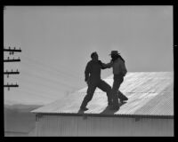 Two men fighting on a roof in an unidentified film, 1940s or 1950s