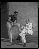 Rick Jason conversing with a seated man during filming of The Saracen Blade, 1953