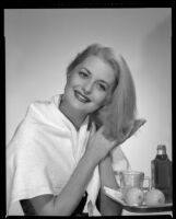 Constance Towers, actress, applying a hair treatment, circa 1955