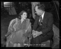 Loretta Young conversing with a man on an outdoor film set, circa 1940-1942