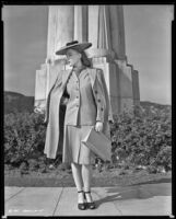 Pat Parrish, actress, posing in front of the Astronomers Monument in Griffith Park, Los Angeles, circa 1944-1945
