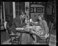 Edith Fellows, actress, sharing a meal with a man, circa 1939