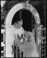 Jack Holt, actor, at a garden gate with his dog, 1934