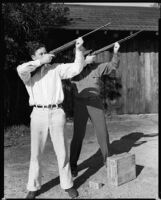 Tim Holt and his father Jack Holt, actor, aiming rifles, probably in their yard, Santa Monica, circa 1934