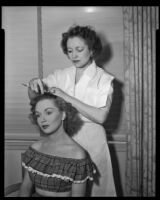 Gloria Henry, actress, having her hair combed by a beautician, circa 1947-1951