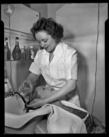 Gloria Henry, actress, having her hair washed by a beautician, circa 1947-1951