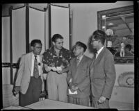 Tyrone Power, actor, conversing with three men, circa 1955