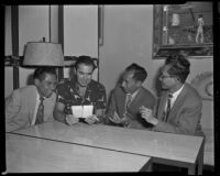 Tyrone Power, actor, and three men discussing items held by Power, circa 1955