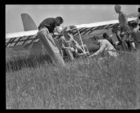Crew helping a man sitting in a glider (possibly during the filming of Gallant Journey), 1946
