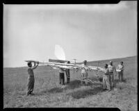 Men carrying a glider in a field (possibly during the filming of Gallant Journey), 1946