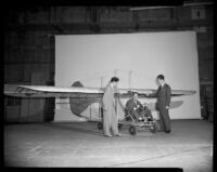 Man sitting in a glider as two men stand next to him (possibly during the filming of Gallant Journey), 1946
